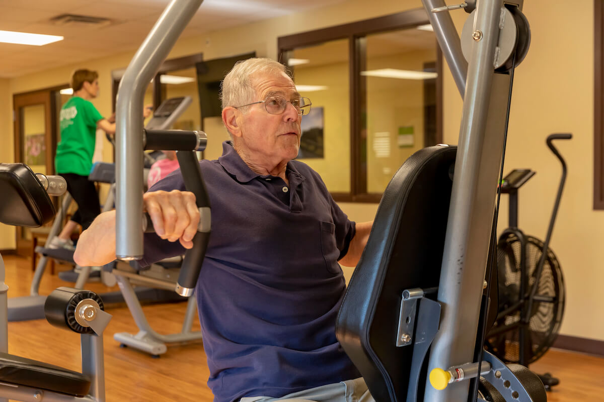 Older Man on exercise machine_Wellness Center at Uplands Village