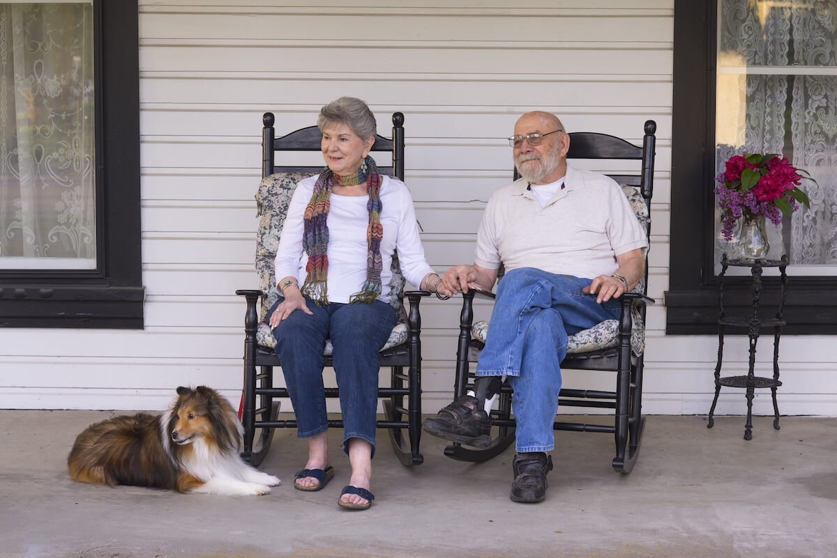senior couple sitting on porch _Benefits of Owning a Home in retirement