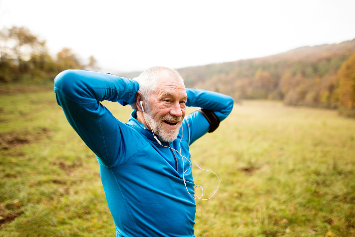 Senior Man Stretching on Hike Through Mountain