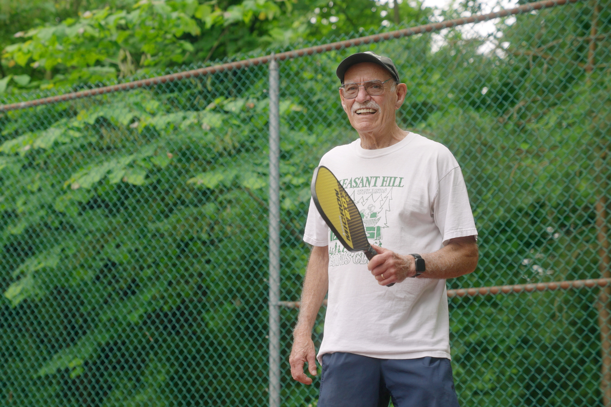 Smiling Senior Man Holding Pickleball Paddle_Uplands Village