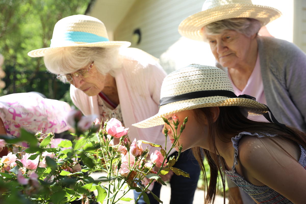 Senior Women and Young Girl Smelling Flowers_Uplands Village