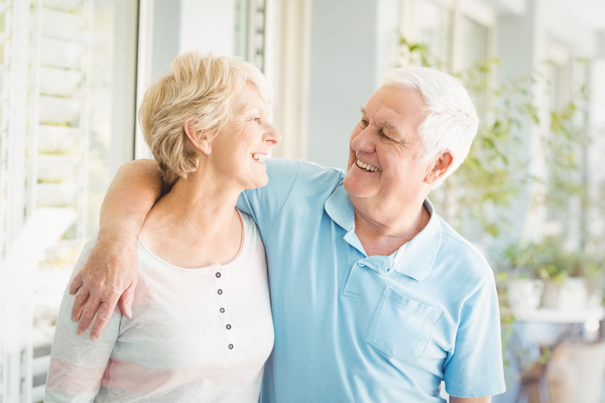 Senior Couple Smiling on Front Porch of Home_Uplands Village