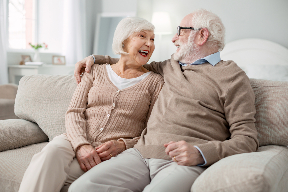 Happy Senior Couple on Couch_Uplands Village