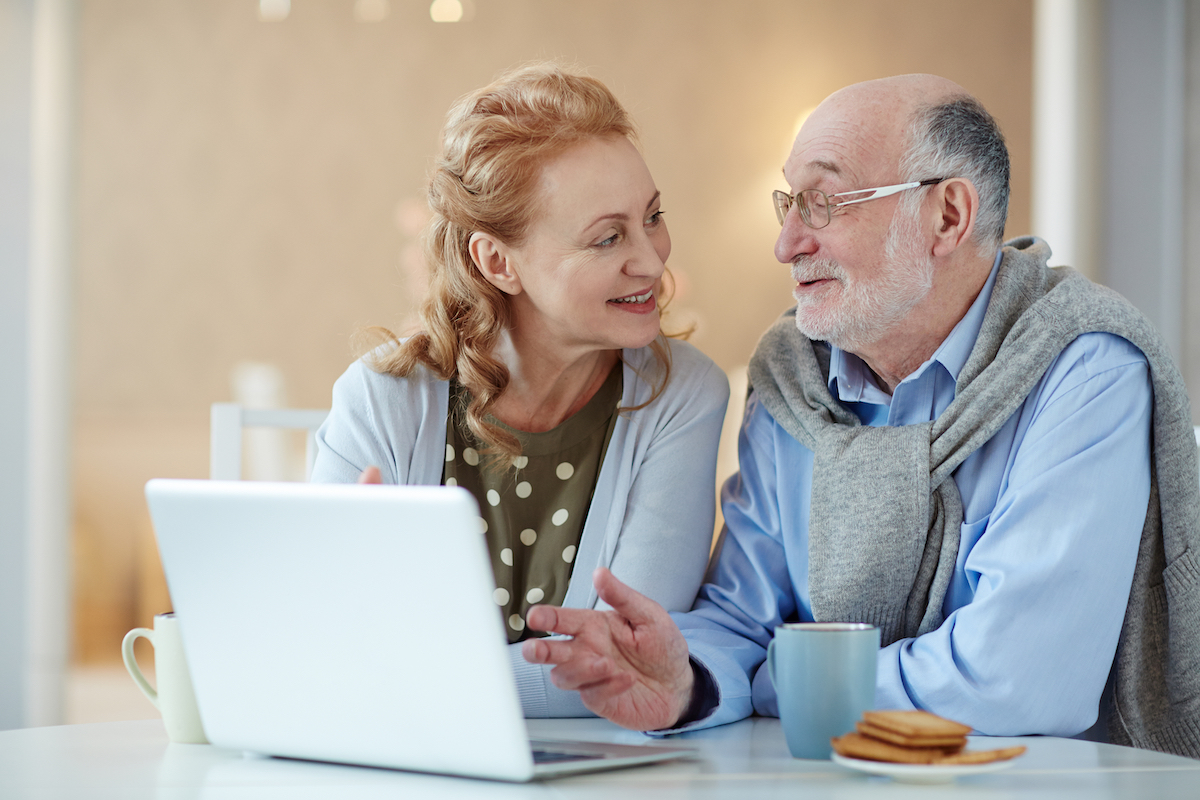 Senior Couple Talking with Open Laptop_Uplands Village