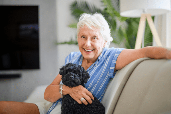 A vibrant senior woman relaxing in her living room with her dog.