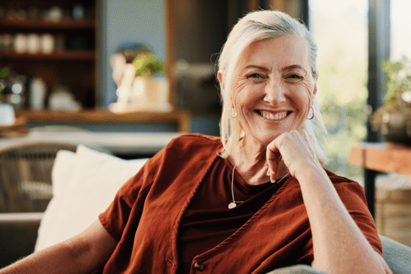 A confident and contented mature woman relaxes comfortably on a sofa, enjoying a well-deserved weekend rest in the lounge during their retirement.